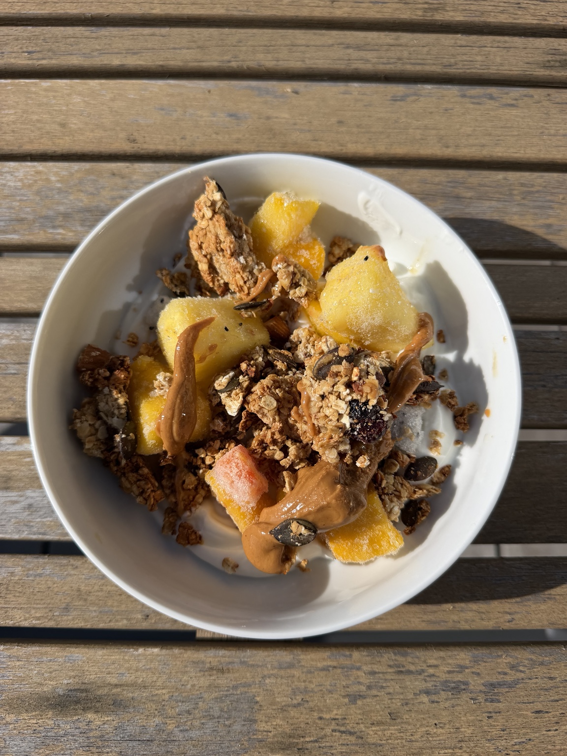 Bol de fruits et de granola sur une table en bois